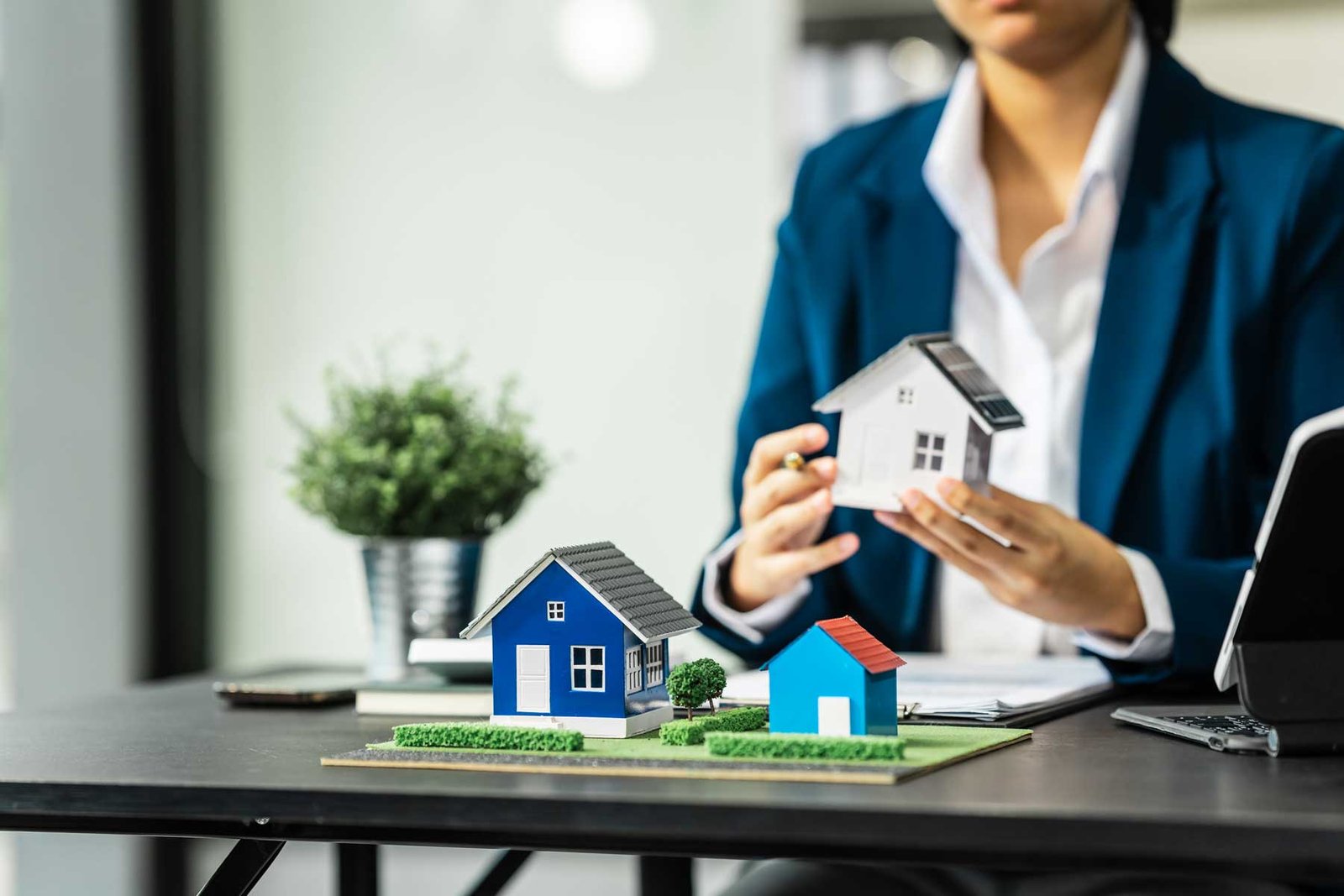 Una agente de bienes raices analizando una maqueta de una propiedad