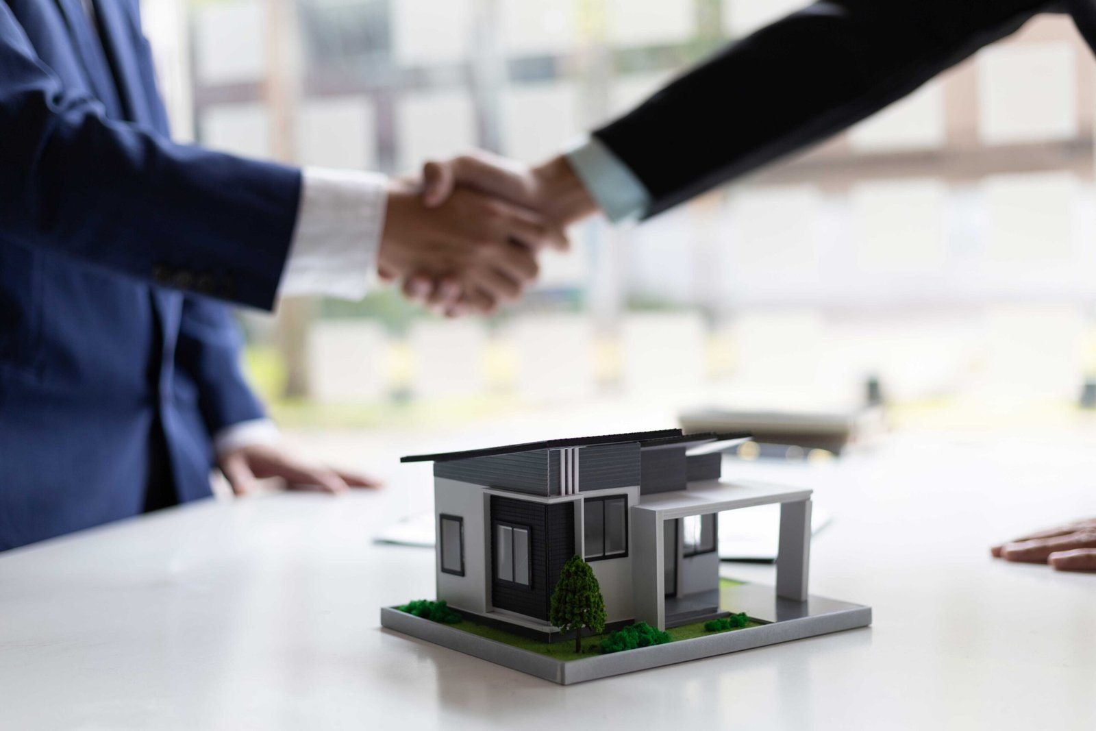 Dos personas haciendo un trato en un estudio inmobiliario